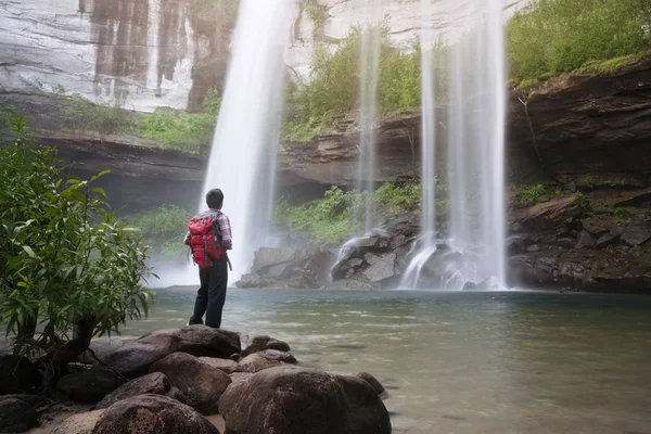 Mochileiro de pé na frente da cachoeira — Fotografia de Stock