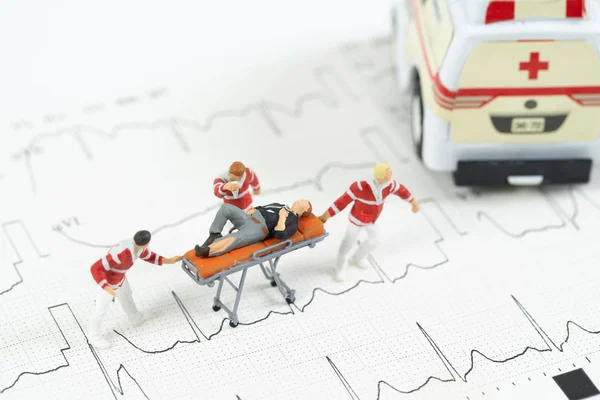 Miniature health care team transport patient to ambulance car