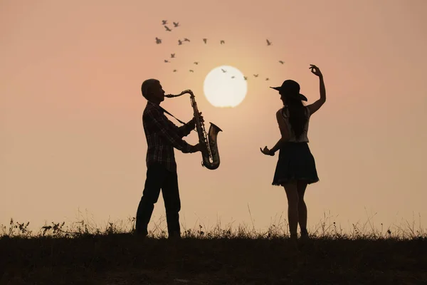 Músico toca saxofón con fondo al atardecer o al amanecer —  Fotos de Stock