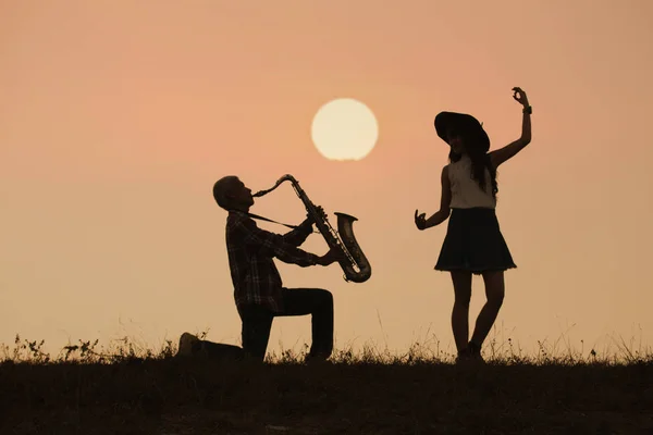 Músico toca saxofón con fondo al atardecer o al amanecer —  Fotos de Stock