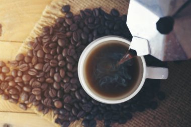 Çuval bezi arka planda kahve çekirdeği ile kahve Beyaz fincan