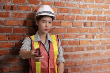 Tuğla duvar arka plan ile Asyalı mühendis kadın