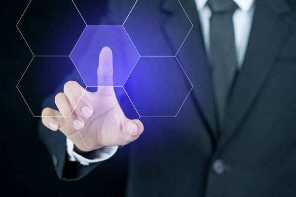 Бизнесмен тычет пальцем в иконку шестиугольника
