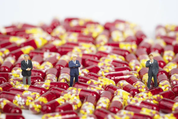 Miniaturní lidé s kapslí z lékařské drogy na bílém pozadí — Stock fotografie