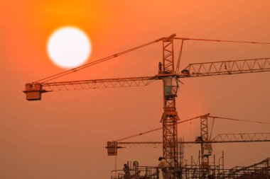 gün doğumu veya gün batımı ile yapım aşamasında bina ve vinç  