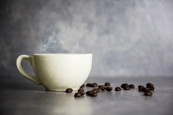 Tazza bianca di caffè e chicco di caffè con sfondo in cemento — Foto Stock
