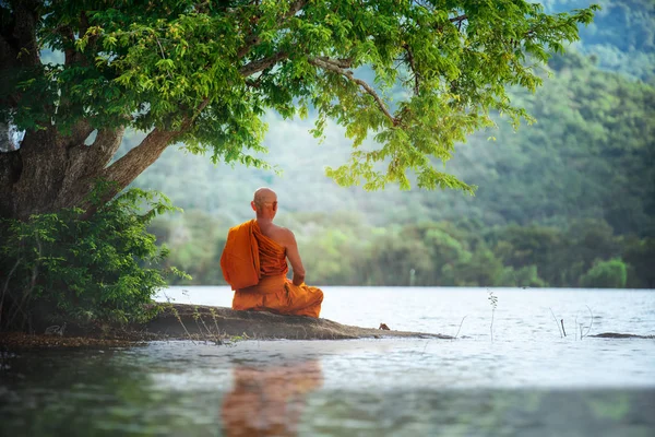 Buddhist monk in meditation beside the river