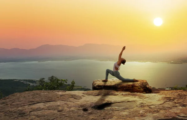 Woman practice yoga on mountain with sunset or sunrise backgroun — Stock Photo, Image