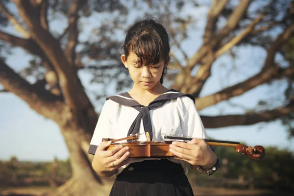 自然の背景を持つバイオリンを保持している女の子 — ストック写真