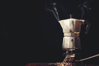 Moka pot eski kahve makinesi ve siyah arka plan üzerinde kahve çekirdekleri