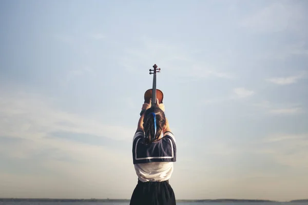 青い背景でバイオリンを弾く少女 — ストック写真