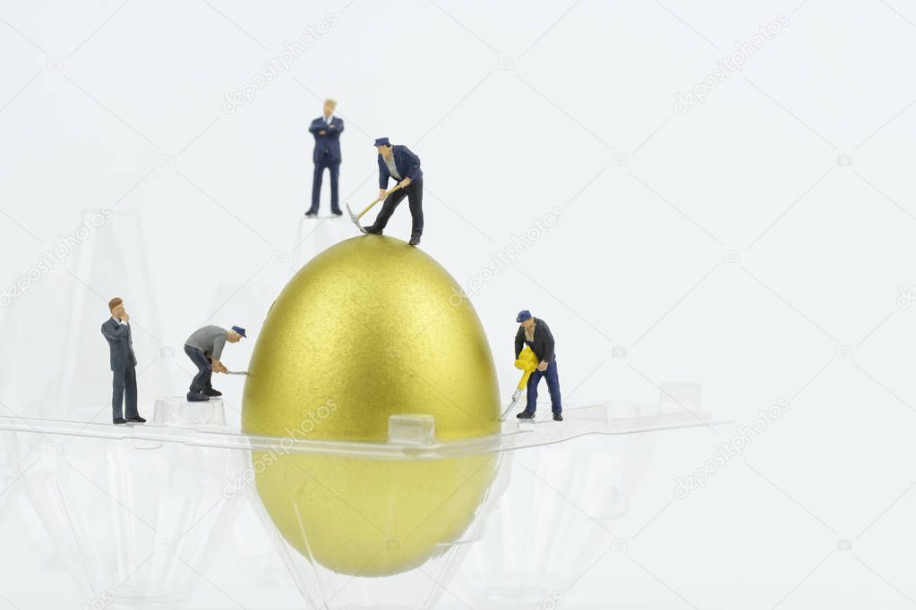 Miniature people with gold egg