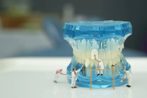 Miniaturní lidé k čištění modelu zubů, koncepce stomatologické péče — Stock fotografie