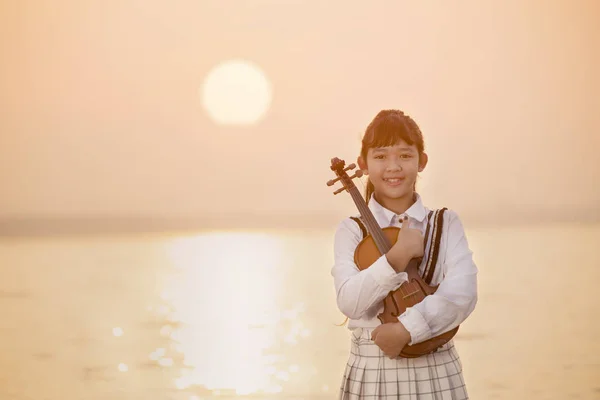 Hermosa chica tocando el violín con fondo de atardecer — Foto de Stock