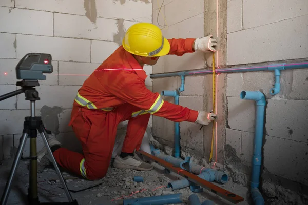 Technicien avec niveau de mesure laser pendant le travail — Photo