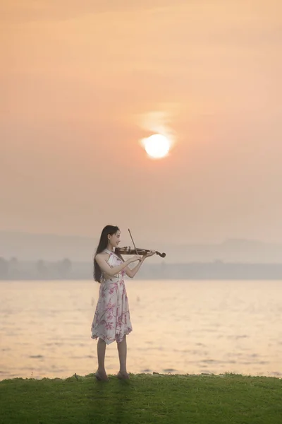 美しいです女性再生バイオリンで海で日の出の背景 — ストック写真