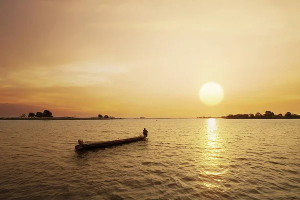 Pescador en el barco con fondo al atardecer o al amanecer — Foto de Stock