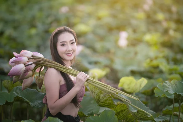 Donna che tiene loto con vestirsi tradizionale in giardino — Foto Stock