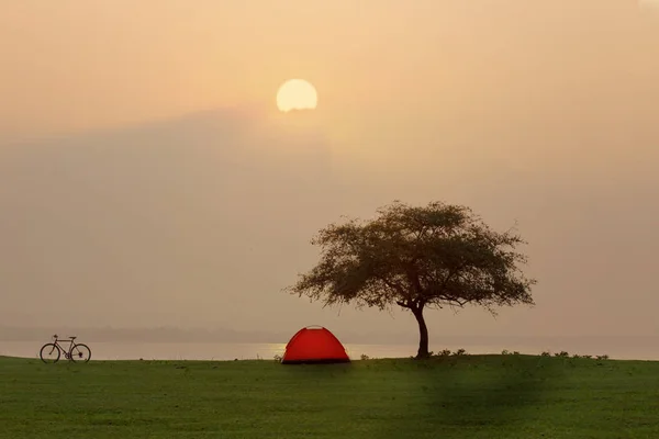 Tienda de campaña en camping junto al mar con puesta de sol o amanecer espalda — Foto de Stock