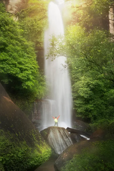 Hombre brazos abiertos con hermosa cascada en la selva tropical —  Fotos de Stock