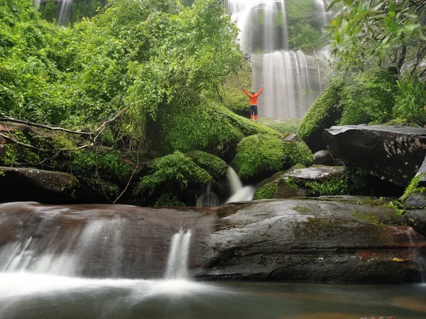 Homem de braços abertos com bela cachoeira na floresta tropical — Fotografia de Stock