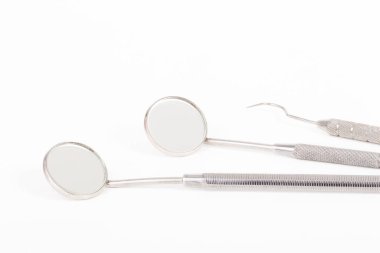 Beyaz arkaplanda diş aracı aynası ve kanca