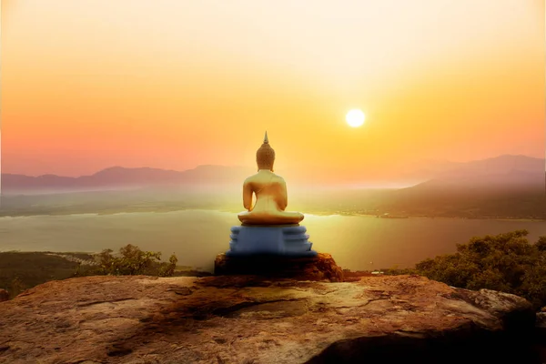 太陽の光を浴びて崖の上に金の仏像の瞑想 — ストック写真