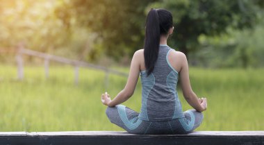 Kadın doğada yoga yapıyor.