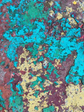 Old grunge vintage background: color concrete surface with green blue yellow red violet paint flaking clipart