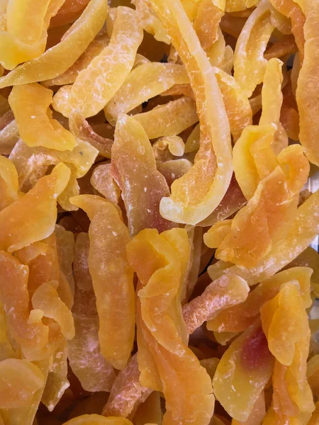 Dried melon on the market. Delicious sweet slices of yellow dried melon background