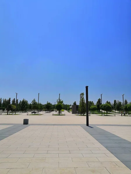 City Park blue sky, tiles, lights, trees background. The track is lit by modern street lights. — Stock Photo, Image