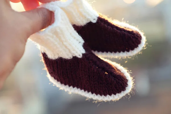 Knit baby booties for newborn from yarn, close up of cute handmade products for footwear