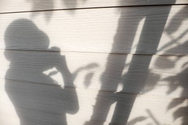 Güneşli akşam arka plan, gölge insanlar ve yaprak beyaz duvar ev, siluet kadın almak fotoğraf yalnız