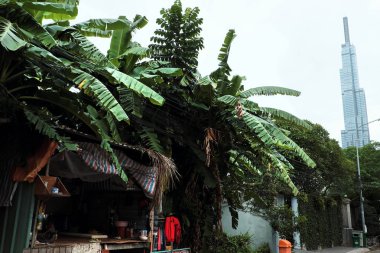 Bölge 2 yaprak kulübe ön plan, zengin ve yoksul, eski arasındaki kontrast ve modern, yeşil ve kırmızı, geçici baraka grubu Muz ağaçlarının altında görünümünden Landmark 81