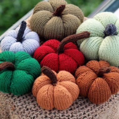 Arka plan bulanık ile sonbahar pumpkins fotoğraf odak iplik korkuluk, yakındaki yeşil arka plana sahip dış tablo üzerinden grup renkli kabak süsleme örgü