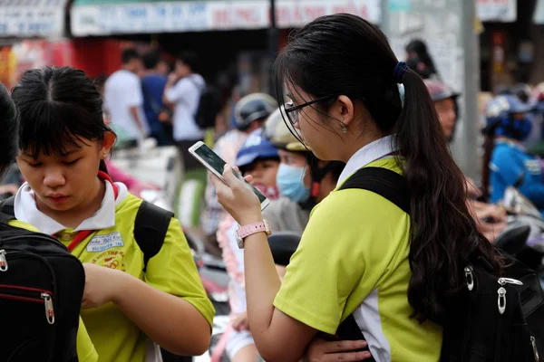 Scuola ragazza stand con il telefono, concentrarsi sullo smartphone dopo la scuola — Foto Stock