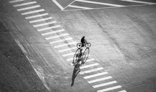 Homme solitaire vélo sur la rue avec une longue ombre — Photo