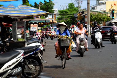 Kadınlar yüksek ateş altında bisiklet sürerler, aşırı hava şartları, Viet...