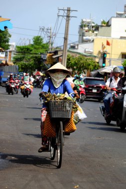 Kadınlar yüksek ateş altında bisiklet sürerler, aşırı hava şartları, Viet...