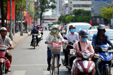 Kadınlar yüksek ateş altında bisiklet sürerler, aşırı hava şartları, Viet...