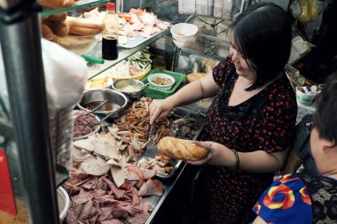 Vietnamlı kadın gece sokak gıda sepeti vietnam ekmeği satmak