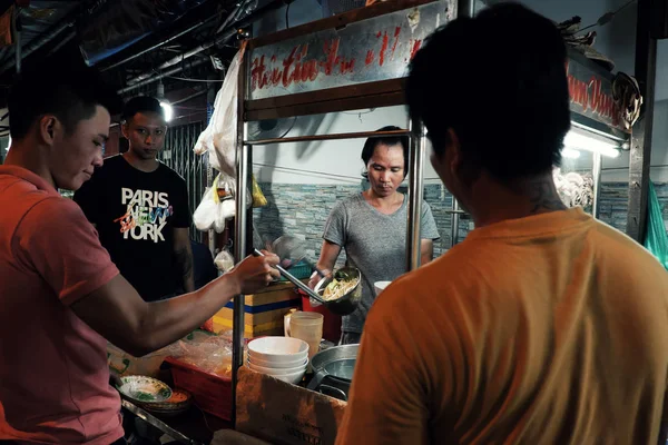 Vietnamita homem venda cozinhar sopa de macarrão no carrinho de comida na noite stree — Fotografia de Stock