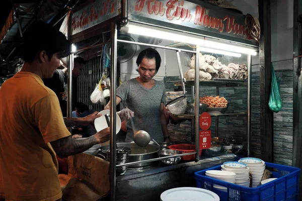 Vietnamita homem venda cozinhar sopa de macarrão no carrinho de comida na noite stree — Fotografia de Stock