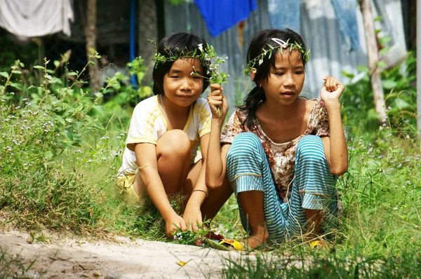 Dos niñas bonitas recogiendo flores silvestres para hacer la corona de la cabeza —  Fotos de Stock