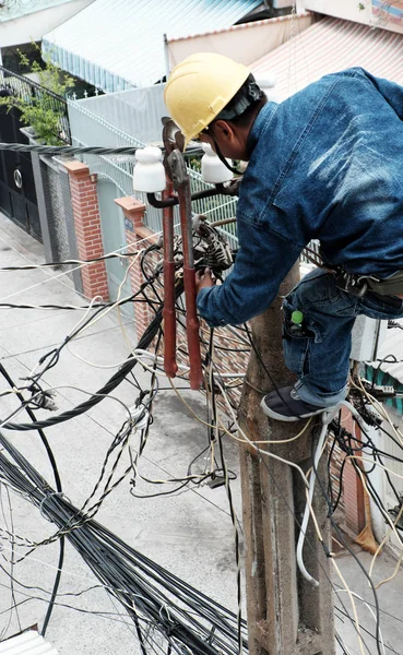 Trabalhador da eletricidade vietnamita subir alto no poste elétrico para representar — Fotografia de Stock