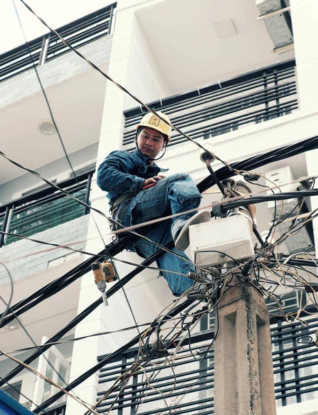 Вьетнамский электрик забирается высоко на электрический пост, чтобы представиться — стоковое фото