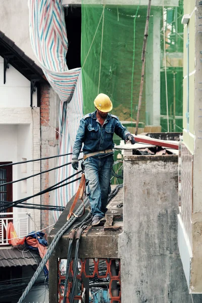 Trabalhador da eletricidade vietnamita subir alto no telhado da casa para reparar — Fotografia de Stock