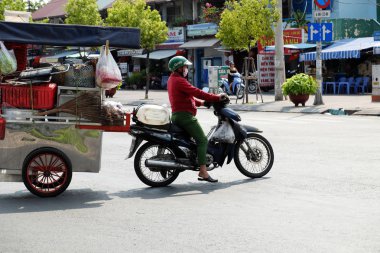 Vietnamlı kadın binmek motosiklet çekin gıda sepeti durdurmak üzerinde sokak