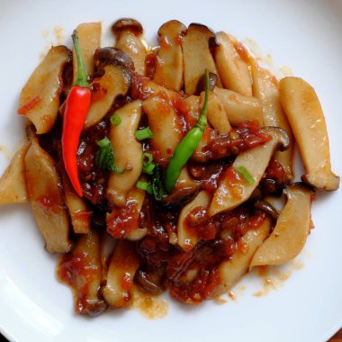 beyaz plaka üzerinde domates soslu kral istiridye mantar aşçı