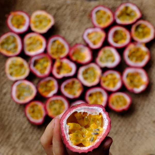 Passion fruits cut in half in heart shape background — Stock Photo, Image